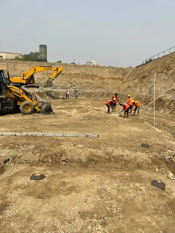 Backhoe loader and site crew during excavation work